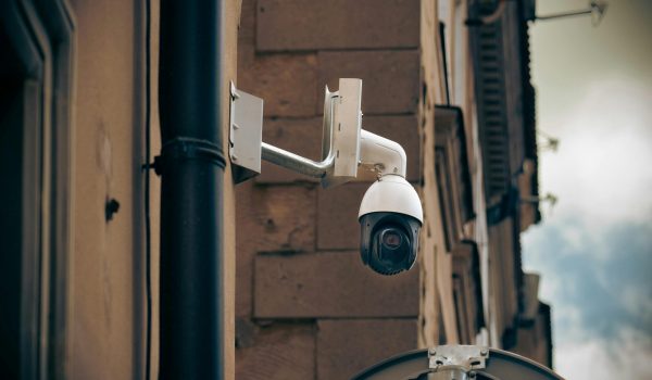 CCTV camera mounted on a building wall in an urban street setting, enhancing security.